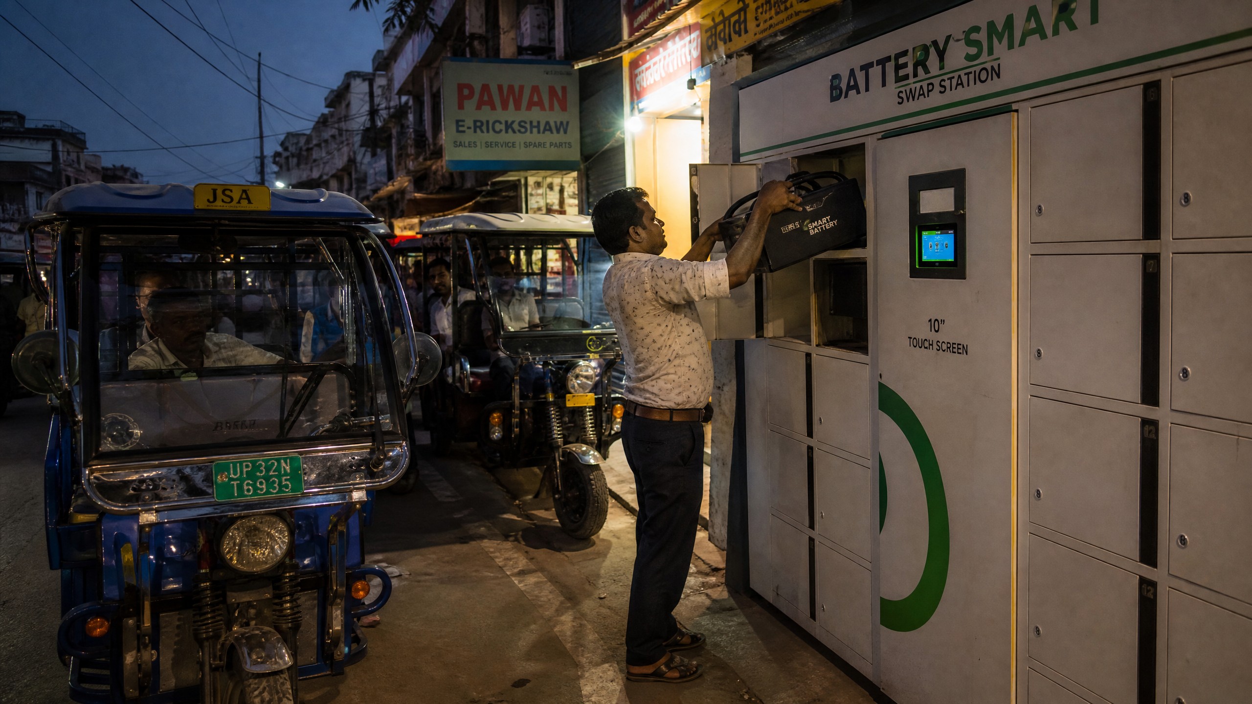 E rickshaw driver at a battery swap station, swap events tracked by electric three wheeler telematics